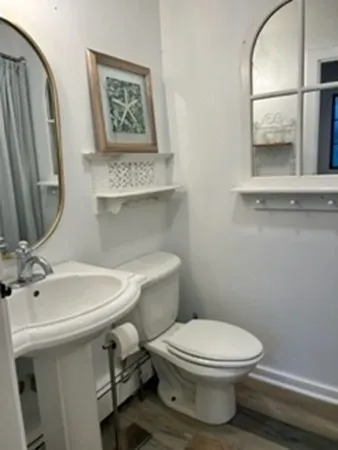a bathroom with a toilet a sink and mirror
