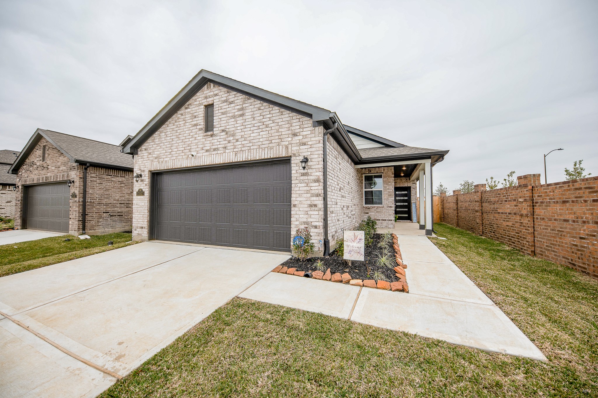23302 Spring Genesis Lane Katy, TX 77493 - Photo 3 of 32 One story brick home with a two-car garage and a neat driveway. The front yard features a landscaped area with a welcoming path leading to the entrance.