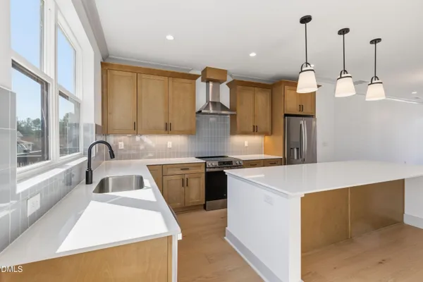 a kitchen that has a sink a stove and a wooden floor