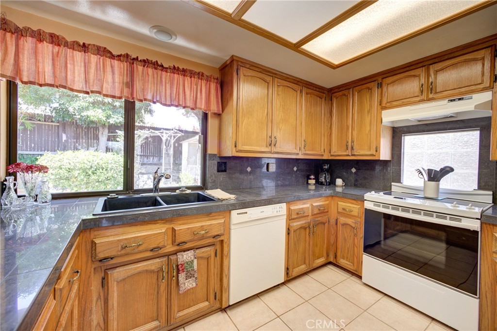 4185 Vanguard Drive Lompoc, CA 93436 - Photo 16 of 44 a kitchen with stainless steel appliances granite countertop a stove a sink and white cabinets