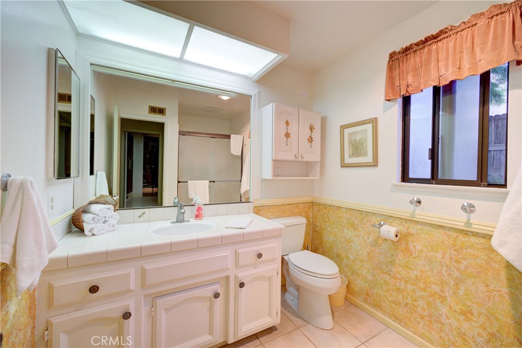 4185 Vanguard Drive Lompoc, CA 93436 - Photo 26 of 44 a bathroom with a granite countertop sink toilet a large mirror and a bathtub