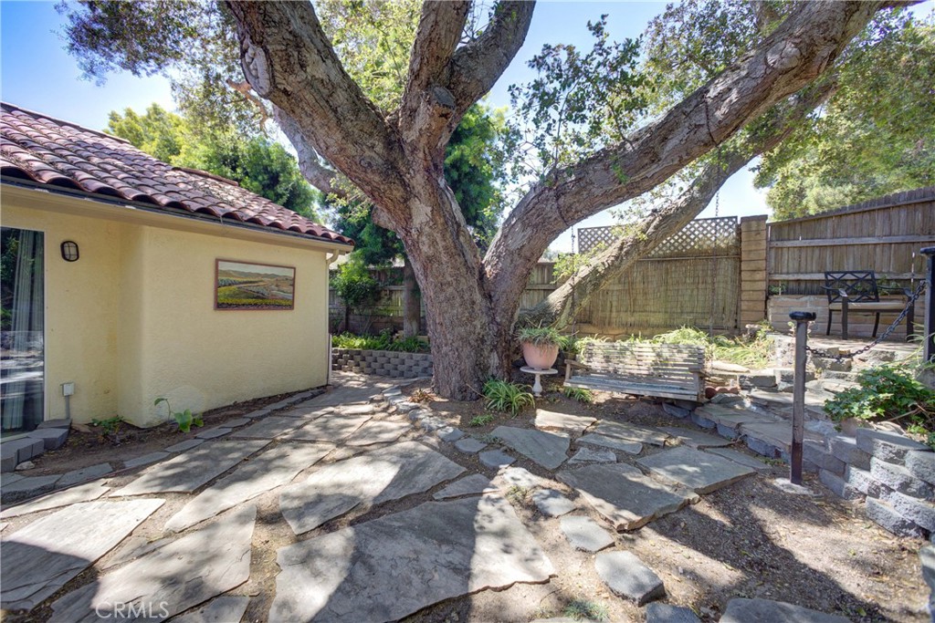 4185 Vanguard Drive Lompoc, CA 93436 - Photo 40 of 44 a backyard of a house with table and chairs under an large tree