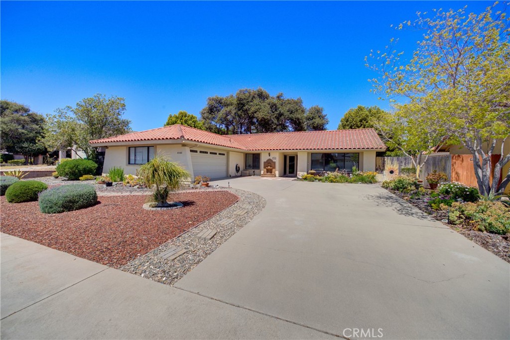 4185 Vanguard Drive Lompoc, CA 93436 - Photo 42 of 44 a view of a white house with a big yard and table and chairs under an umbrella