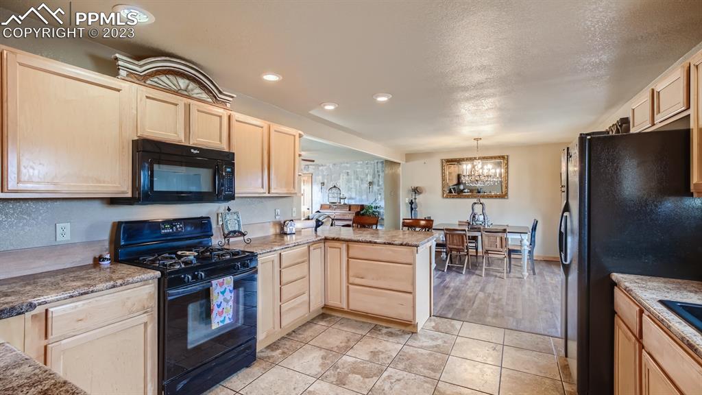 29 Ridge Point Circle Divide, CO 80814 - Photo 18 of 50 a kitchen with stainless steel appliances granite countertop a stove top oven a sink a dining table and chairs