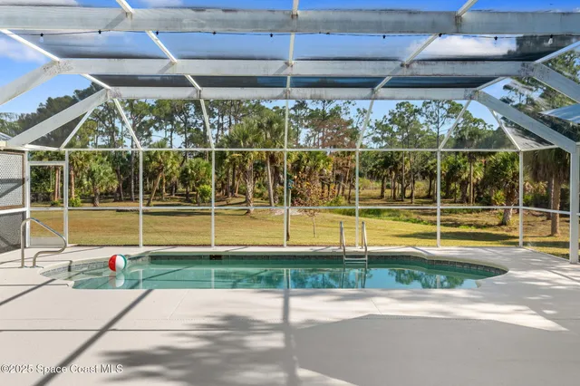 a view of a house with backyard water fountain and sitting area
