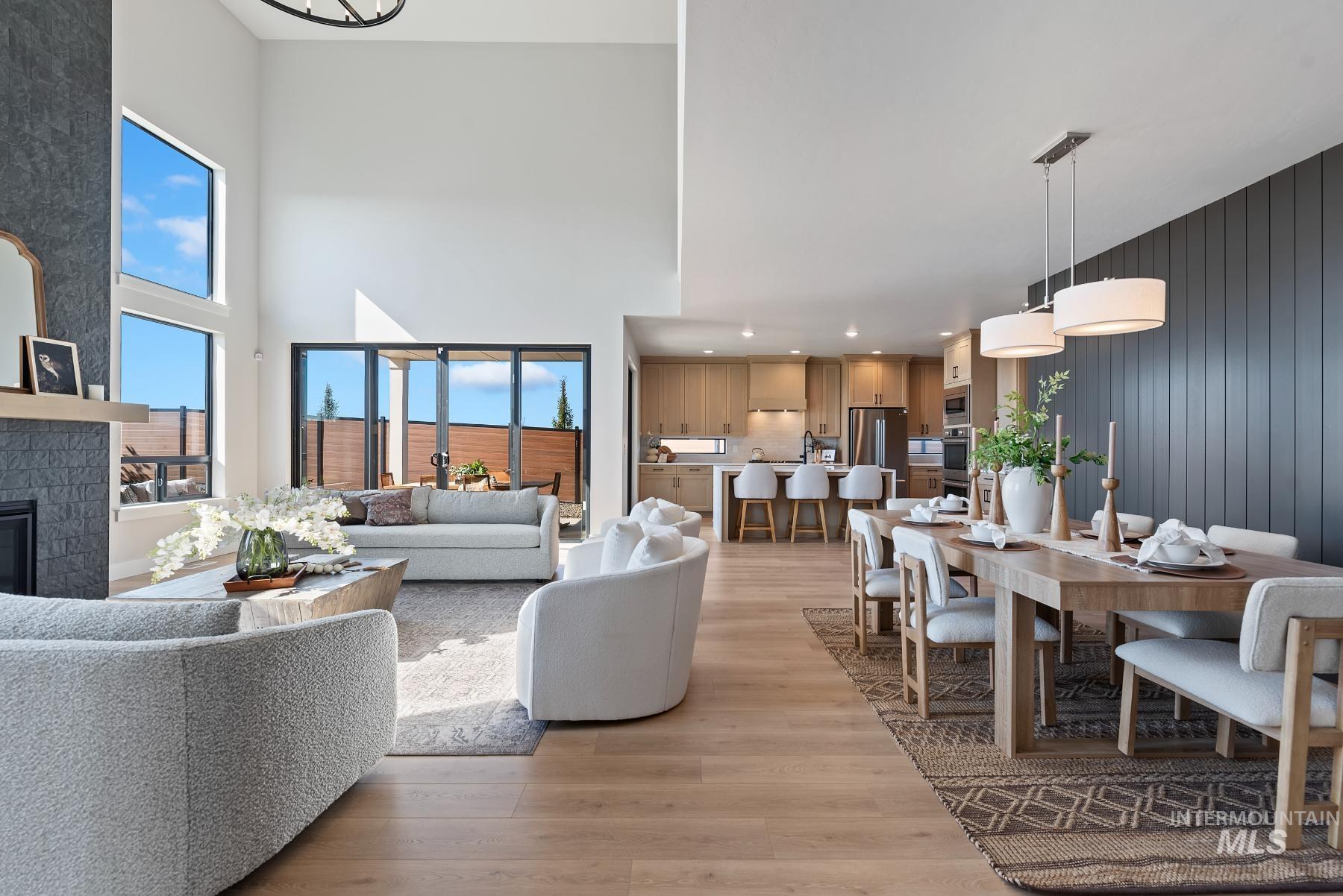 8410 West Graye Street, Unit ALPINE Meridian, ID 83646 - Photo 5 of 45 Vaulted ceiling living area featuring wood-finish flooring, a full-height stone fireplace, and a light wood mantel