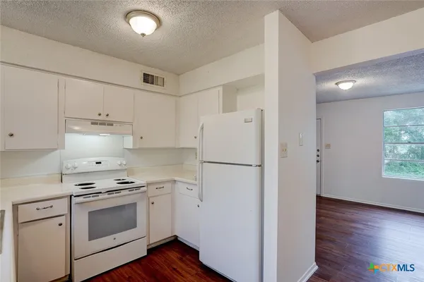 a kitchen with white cabinets and white appliances