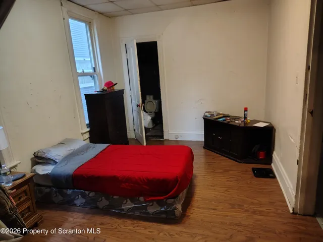 a bedroom with a bed and a flat tv screen on wall