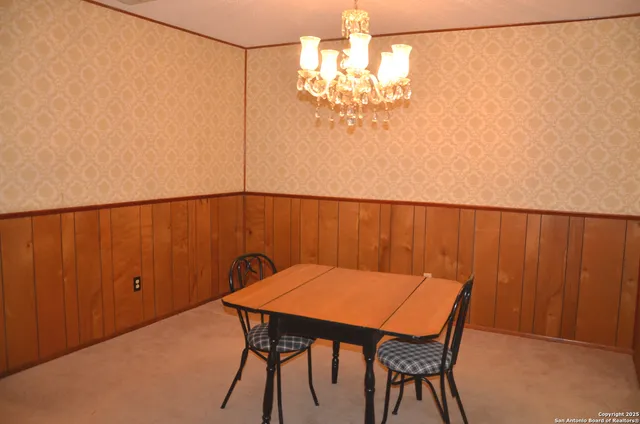 a view of a dining room with furniture and chandelier