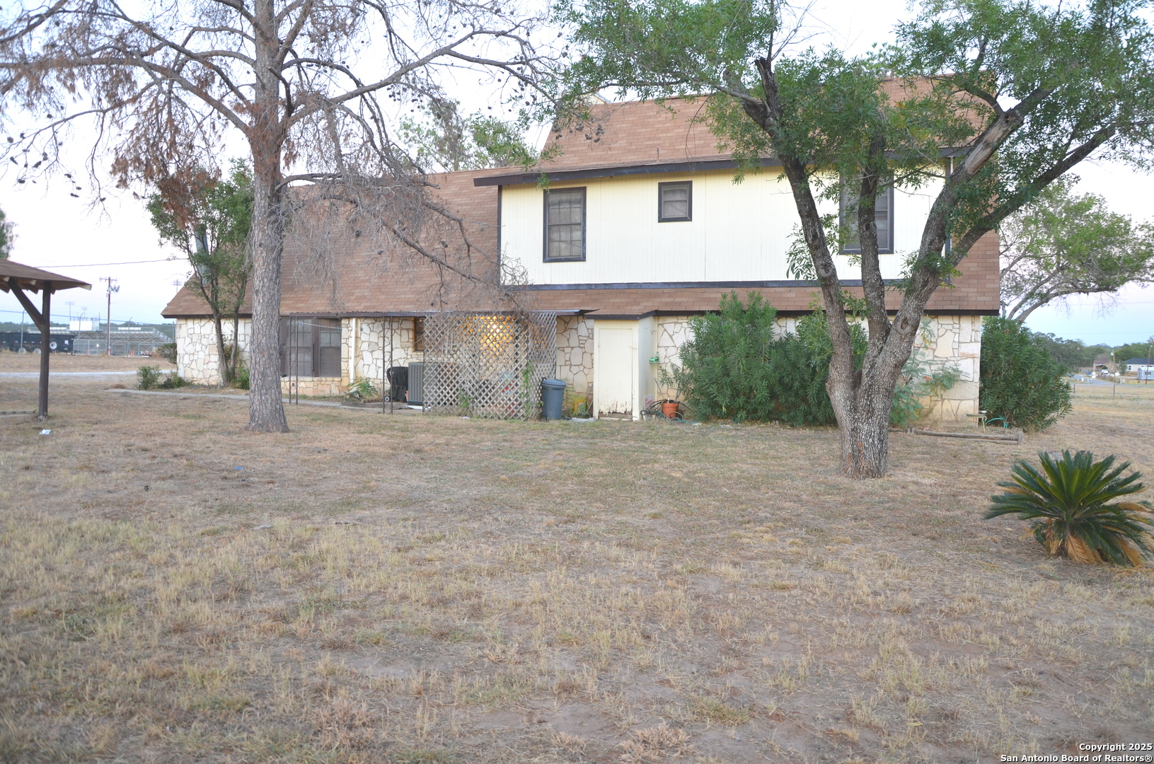 115 B Littleton Drive Devine, TX 78016 - Photo 20 of 27 a front view of a house with garden