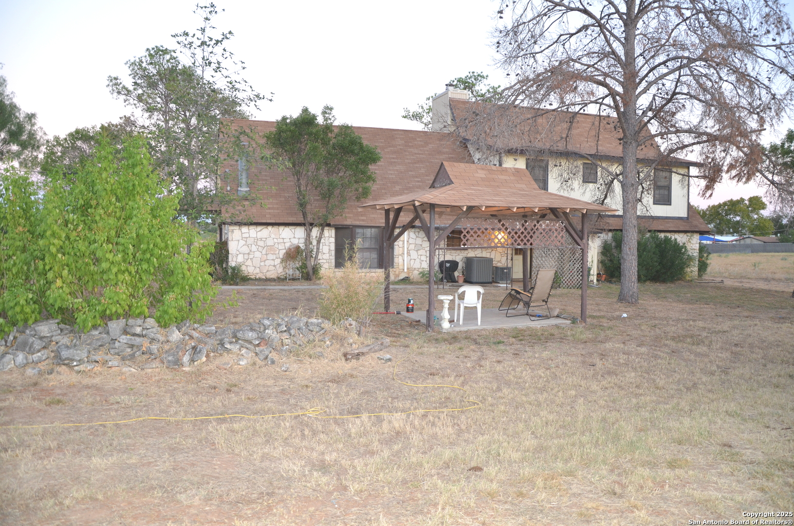 115 B Littleton Drive Devine, TX 78016 - Photo 21 of 27 a white house that has a tree in front of it