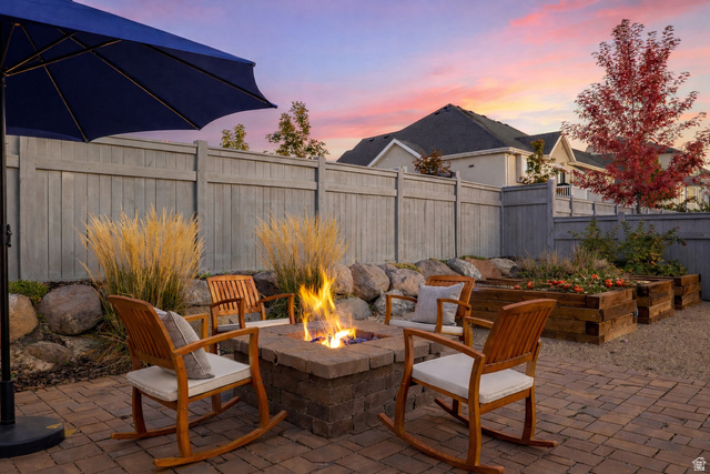 11617 South Wildrye Field Way Draper, UT 84020 - Photo 41 of 53 Patio terrace at dusk with a patio area, a fenced backyard, and an outdoor fire pit