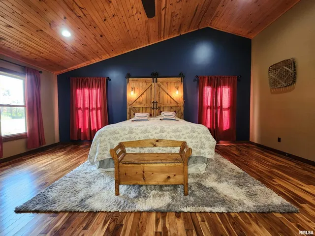 a bed sitting in a spacious bedroom next to a window