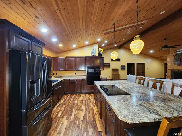 a kitchen with stainless steel appliances granite countertop a sink a stove refrigerator and cabinets