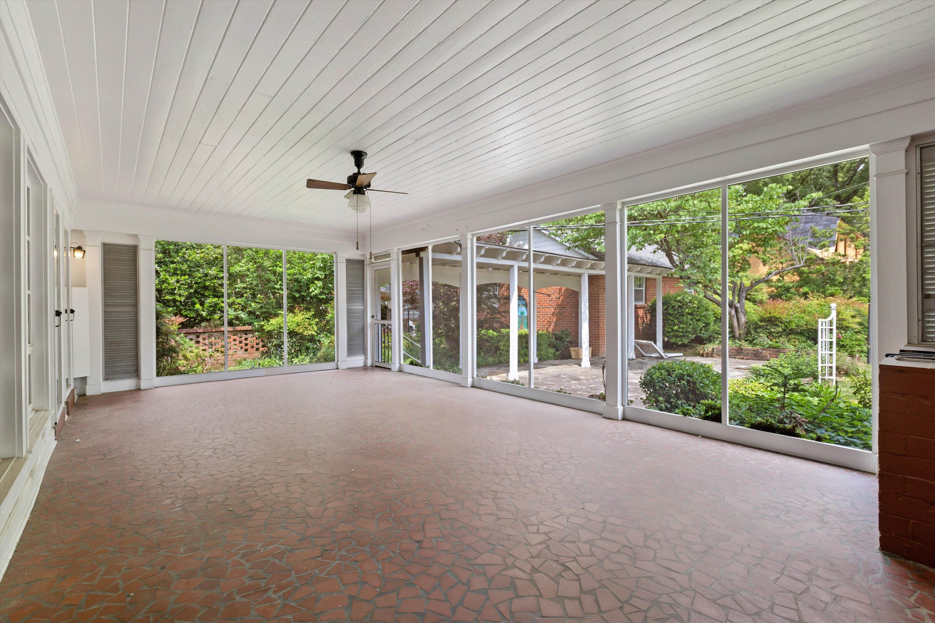 3758 Walnut Grove Road Memphis, TN 38111 - Photo 25 of 34 Expansive Screened Porch (28x15) - with ceiling fan and brick flooring, surrounded by windows overlooking lush landscaping—perfect for relaxing or entertaining. Virtually Staged Photo