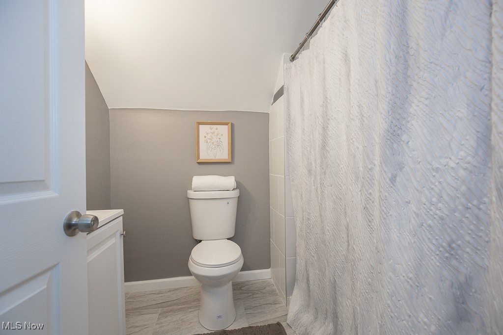 1547 Genesee Road South Euclid, OH 44121 - Photo 17 of 36 Full bath featuring toilet, vaulted ceiling, a shower with curtain, and baseboards
