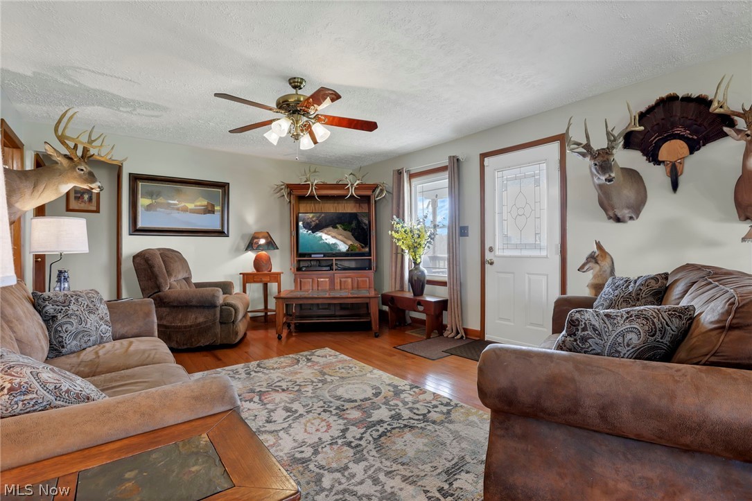 5502 Dutch Ridge Road New Straitsville, OH 43766 - Photo 13 of 49 Living area with wood finished floors, a textured ceiling, and ceiling fan