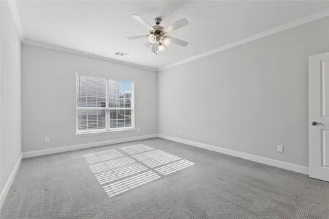 an empty room with windows and ceiling fan