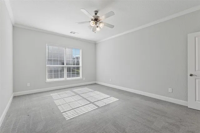 an empty room with windows and ceiling fan
