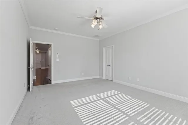 a view of a room with a ceiling fan and hardwood floor