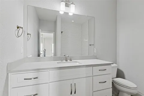 a bathroom with a sink a toilet and mirror