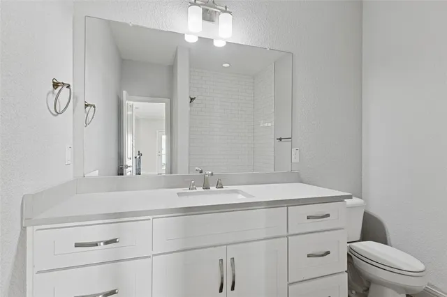 a bathroom with a sink a toilet and mirror