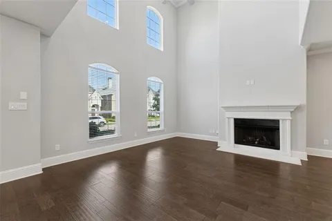 an empty room with wooden floor a fireplace and a window