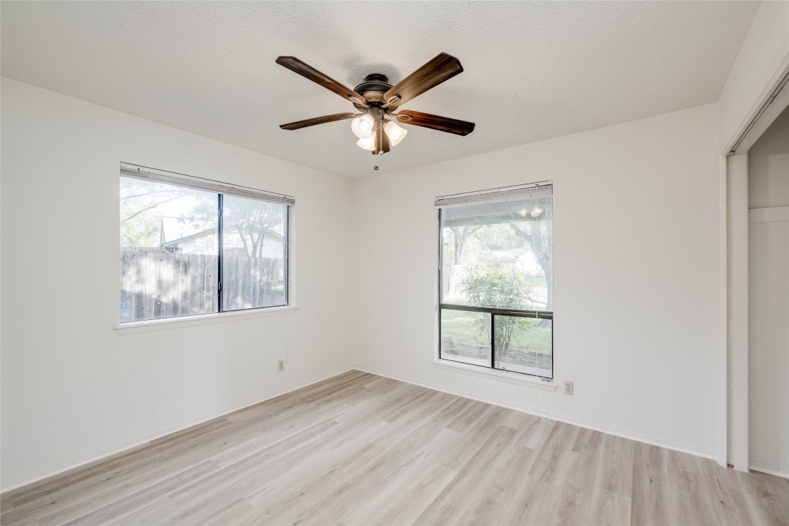 1402 Meadgreen Circle Austin, TX 78758 - Photo 12 of 35 Unfurnished bedroom with a closet, light wood-style floors, and ceiling fan