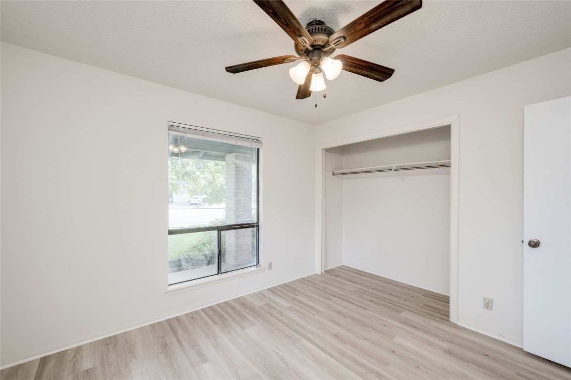 1402 Meadgreen Circle Austin, TX 78758 - Photo 22 of 35 Unfurnished bedroom with light wood-style floors, a closet, and ceiling fan