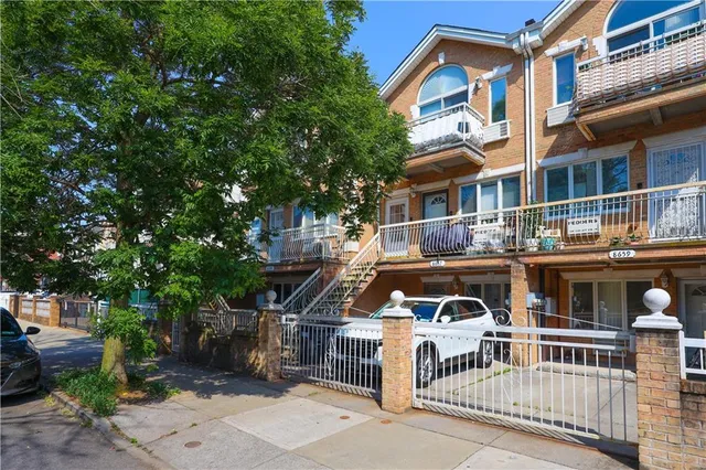 a front view of a residential apartment building with a yard