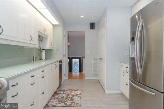a kitchen with stainless steel appliances granite countertop a refrigerator and a stove