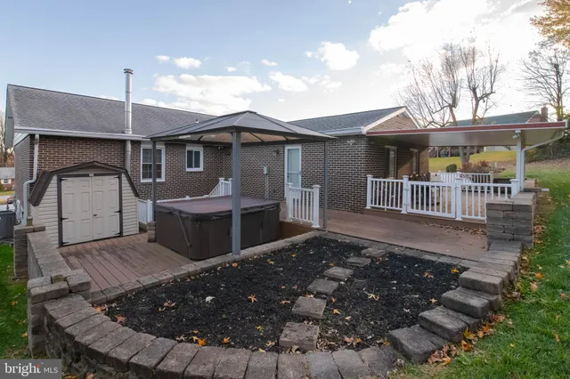 a view of a patio with table and chairs with wooden floor and fence