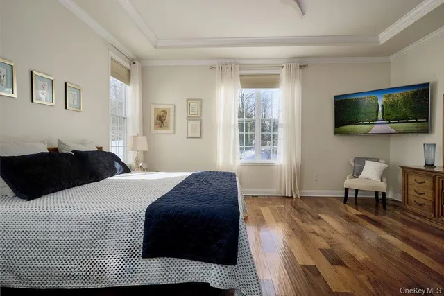 a spacious bedroom with a bed and wooden floor