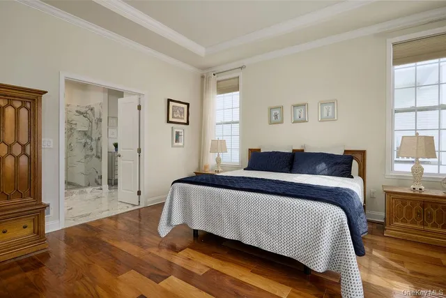 a spacious bedroom with a bed and a flat screen tv