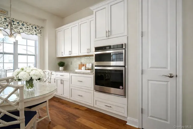 a kitchen with granite countertop white cabinets and white appliances