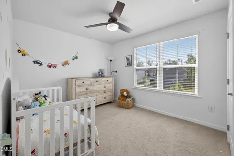a bedroom with furniture a window and a ceiling fan