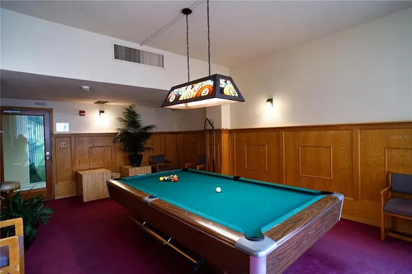 a roof deck with a dining table and chair with wooden floor