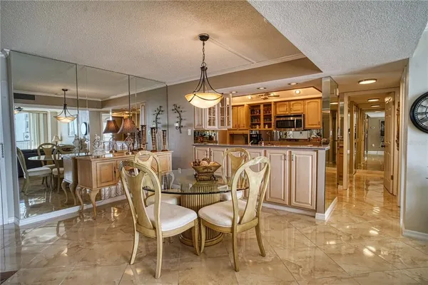 a dining area with glass top table and chairs