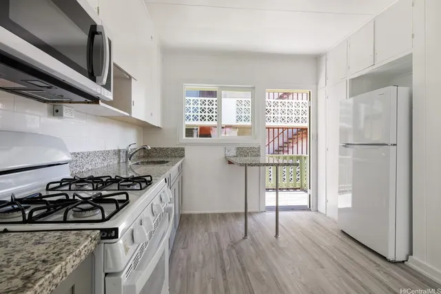 a kitchen with a stove a sink and a window