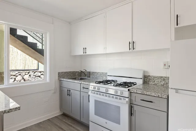 a kitchen with granite countertop white cabinets and white appliances