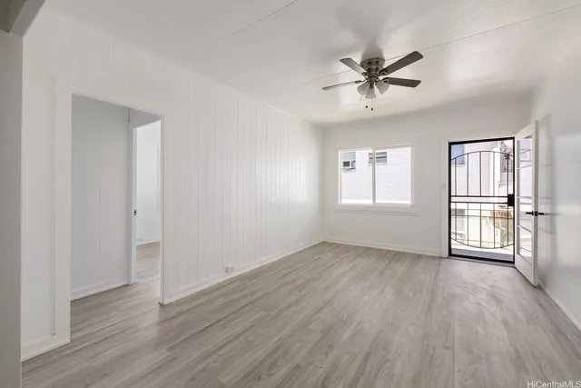 a view of an empty room with a window and wooden floor