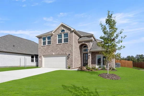 a front view of a house with a garden and yard