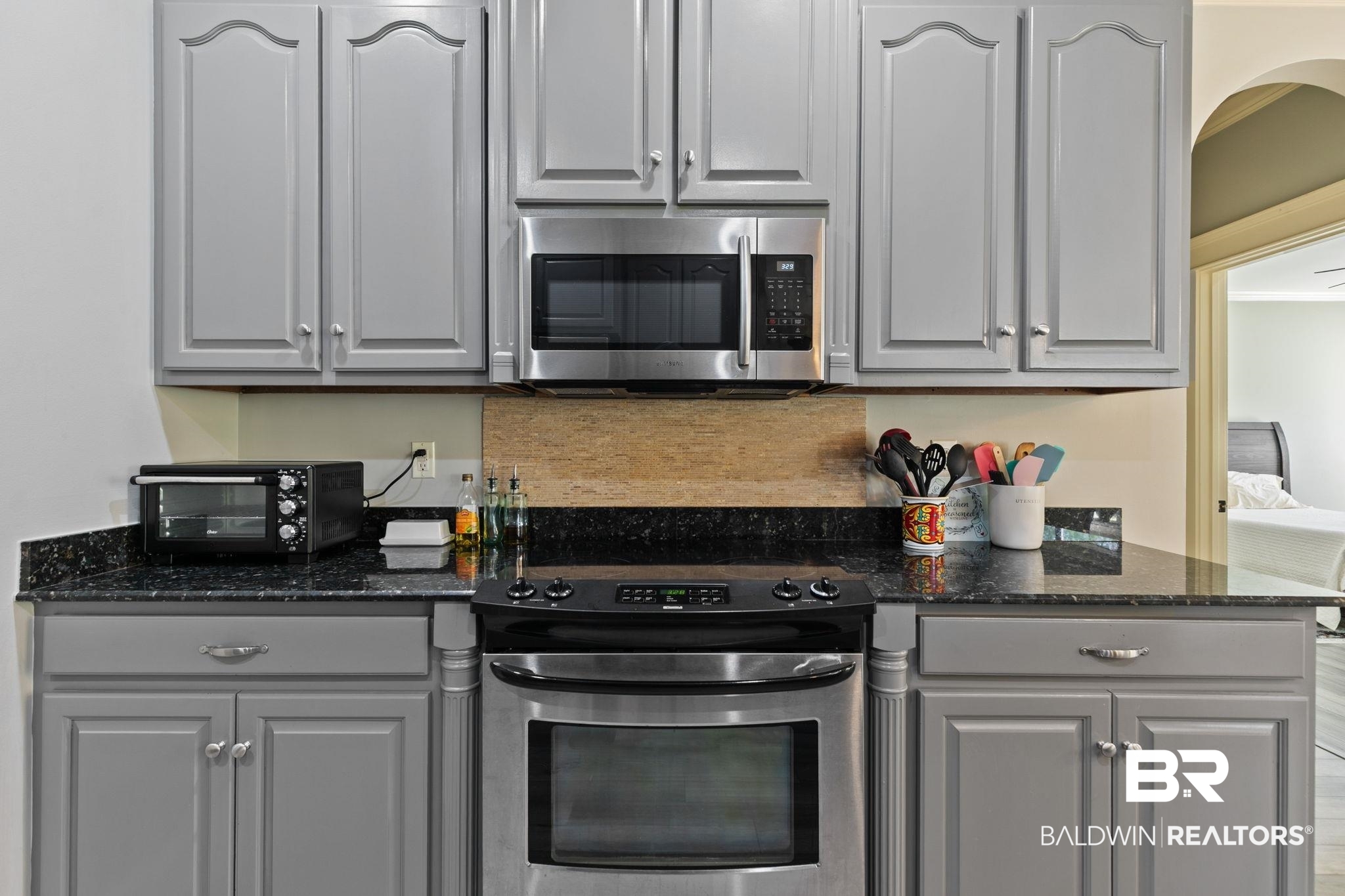 9584 Sanibel Loop Daphne, AL 36526 - Photo 18 of 48 Kitchen with stainless steel appliances, gray cabinetry, and dark stone counters