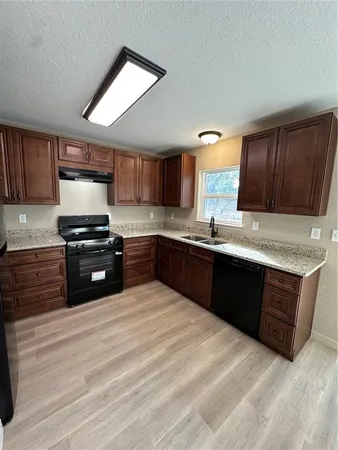 a kitchen with granite countertop a stove and cabinets