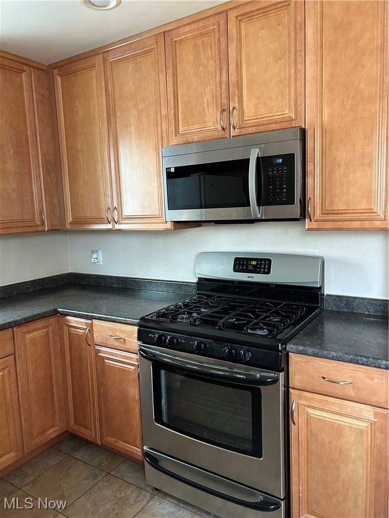1094 Plainfield Road Cleveland, OH 44121 - Photo 6 of 41 Kitchen featuring light tile patterned flooring and appliances with stainless steel finishes