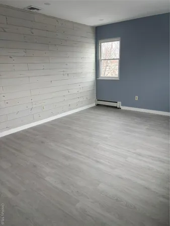 en empty room with wooden floor and windows