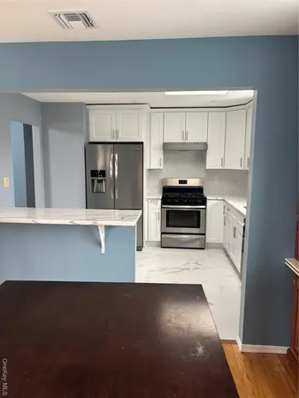 a kitchen with kitchen island a sink stove and refrigerator