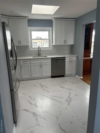 a kitchen with stainless steel appliances a refrigerator sink and window