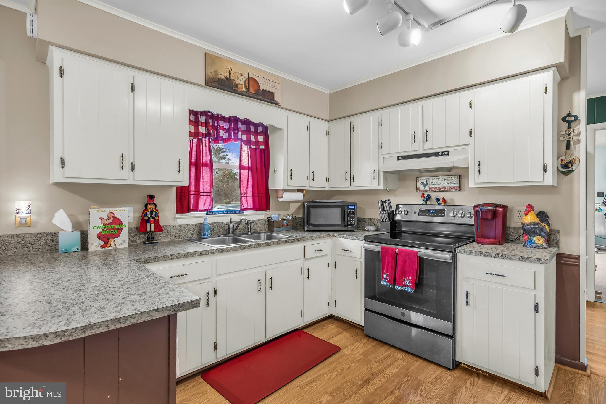 24383 Robins Creek Road Preston, MD 21655 - Photo 13 of 29 a kitchen with kitchen island granite countertop a sink dishwasher white cabinets and wooden floor