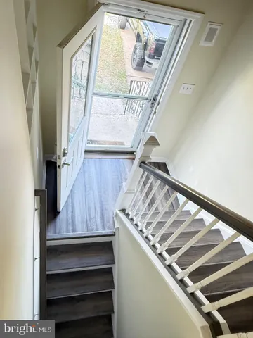 a view of staircase with railing and white walls